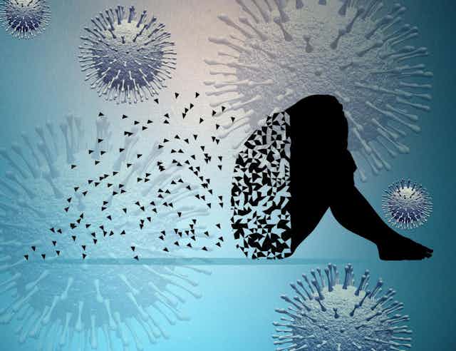 Silhouette of a person sitting with their head on their knees. The silhouette is starting to disintegrate and pieces of the silhouette float away in a blue background of coronaviruses.