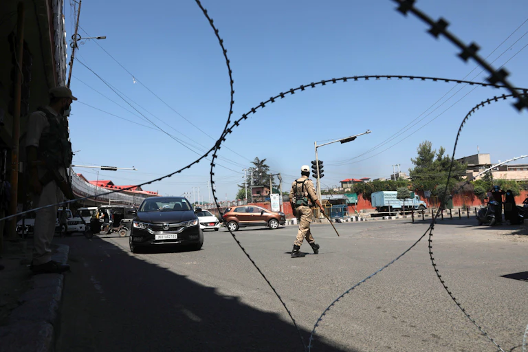 Policeman on street behind barbed wire