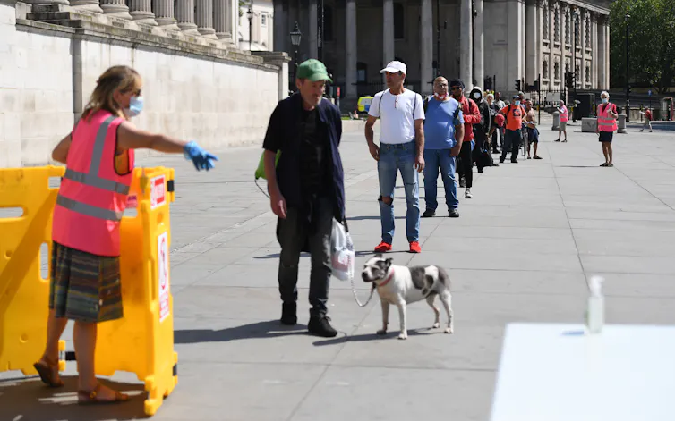 Homeless people queue for food in Trafalgar Square, London.