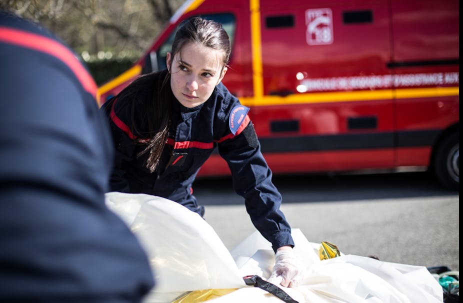 Une sapeuse-pompière des Bouches-du-Rhône prend en charge une victime au cours d'une opération sanitaire avec son équipe.