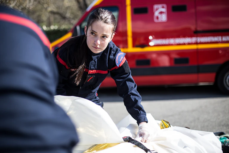 Une sapeuse-pompière des Bouches-du-Rhône prend en charge une victime au cours d'une opération sanitaire avec son équipe.