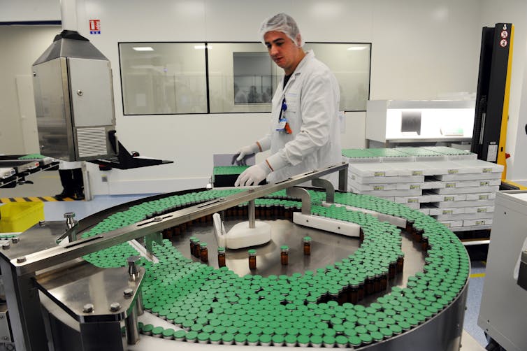 A man overseeing the production of doses of flu vaccine.