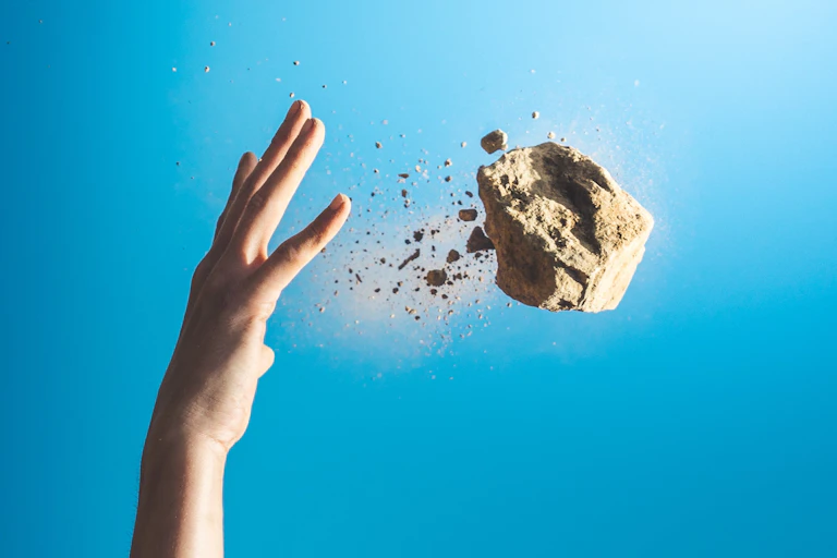 A hand throwing a block of concrete