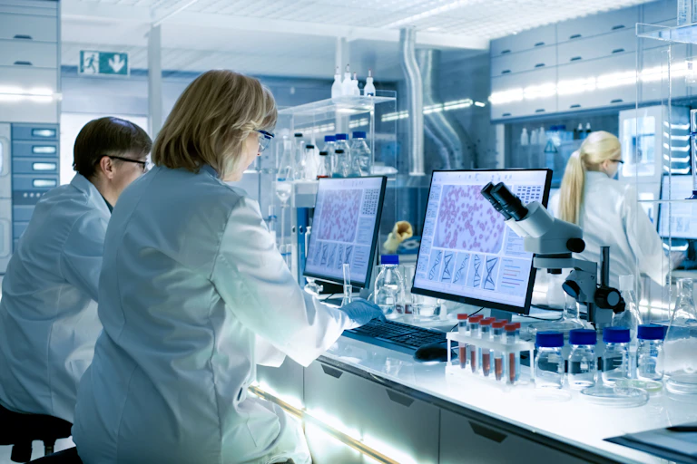 Scientists sitting in front of computers in a laboratory.