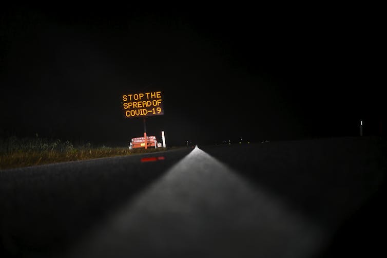 A COVID-19 public health message on a road sign.