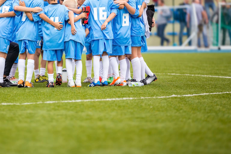 equipo de fútbol infantil abrazándose