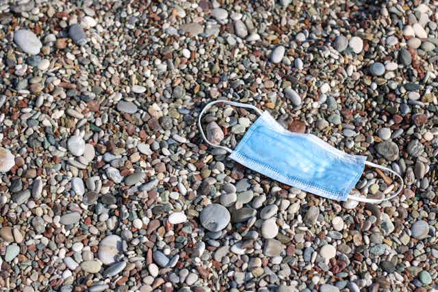 medical mask on beach pebbles