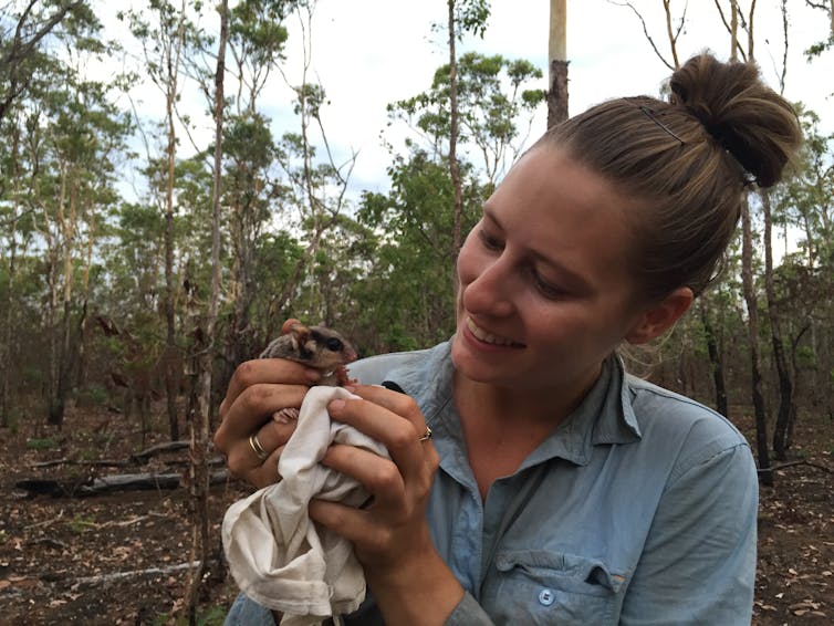 The author smiles at an adorable glider in a little blanket she's holding.