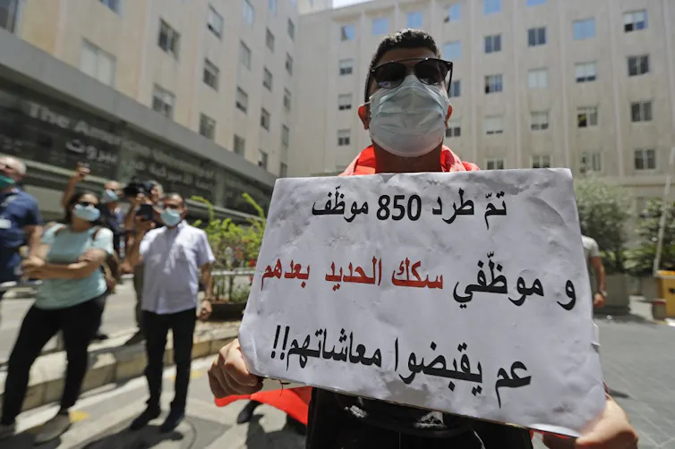 manifestant pancarte licenciements beyrouth crise