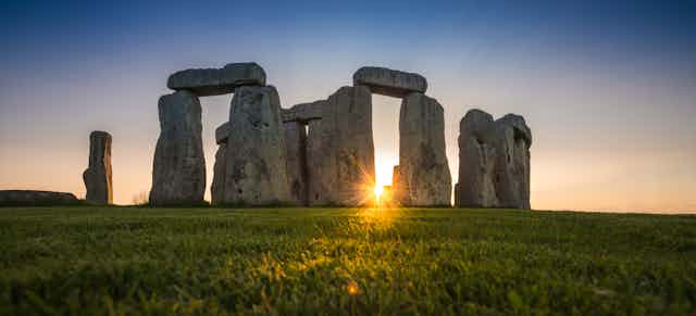 Central stones of Stonehenge at sunset.