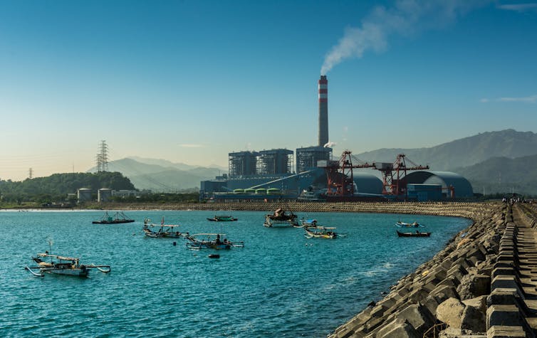 A coastal coal fired power
station in Indonesia surrounded by small boats in the bay.