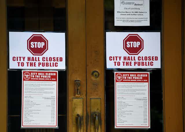 Signs on the main entrance to the the Lynchburg, Virginia, City Hall say it's closed during the outbreak of COVID-19.coronavirus, on May 5, 2020. 