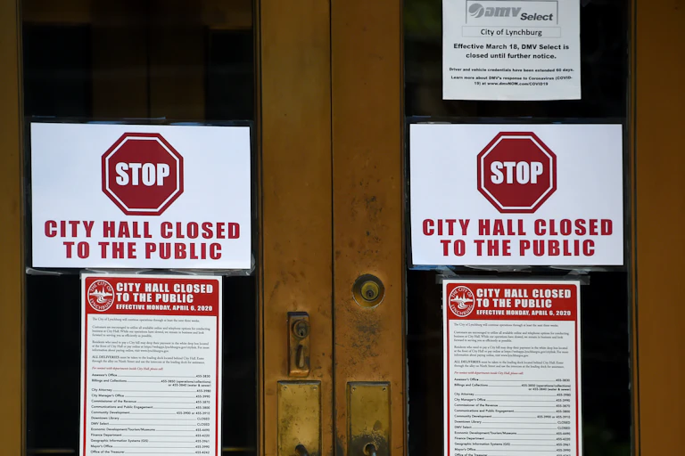 Signs on the main entrance to the the Lynchburg, Virginia, City Hall say it's closed during the outbreak of COVID-19.coronavirus, on May 5, 2020.