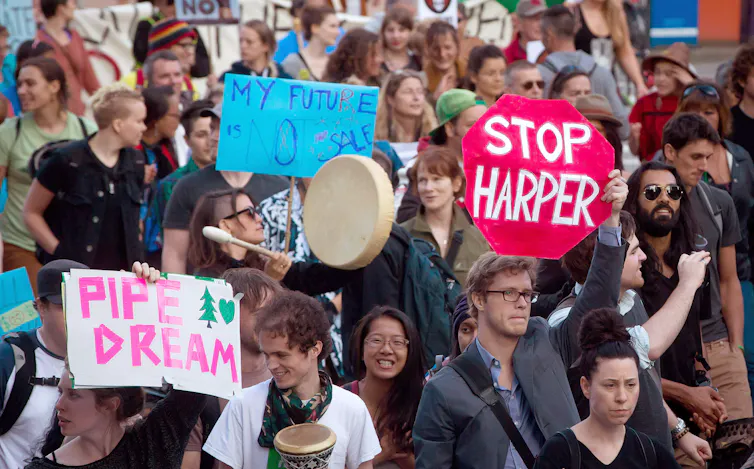 Protesters hold signs and bang drums