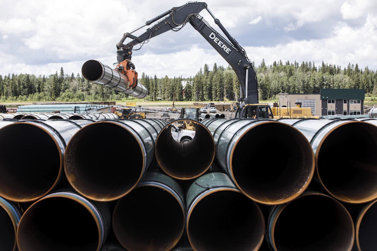 A crane stacks pipes