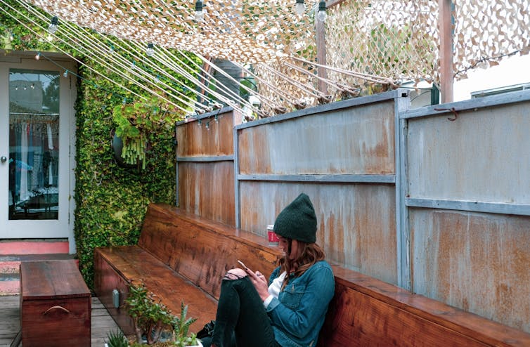 Woman on phone sits alone in cafe