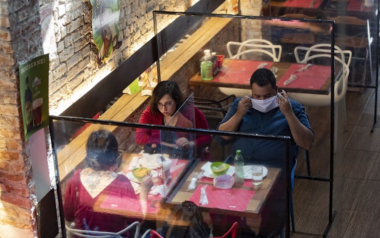 People sitting at a table at a restaurant with glass walls around them