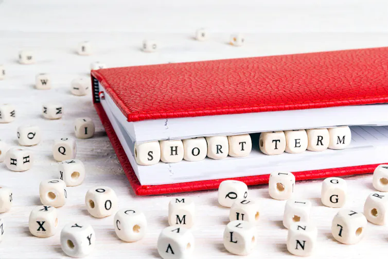 Book with cubes spelling 'short term' between the pages.
