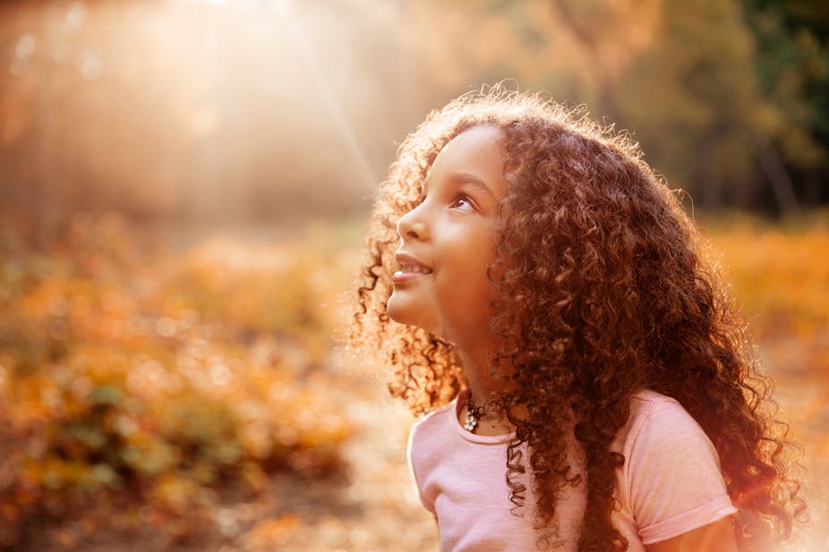 Seorang gadis muda memandang ke matahari.