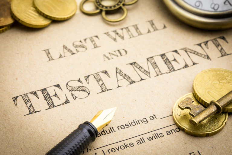 Last will and testament with coins, pen and key