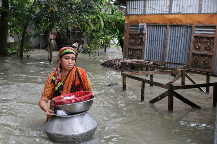 A woman struggles through floodwaters in Bangladesh