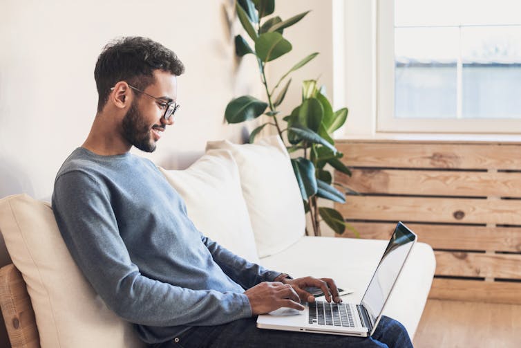 A person enjoying working on their laptop at home