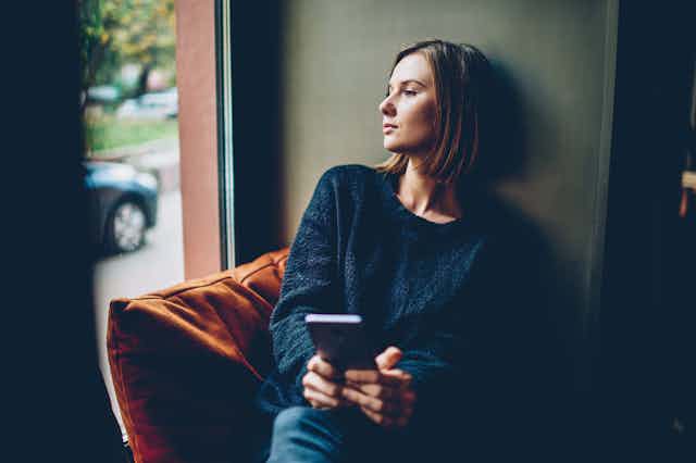 Woman looking out the window pensively