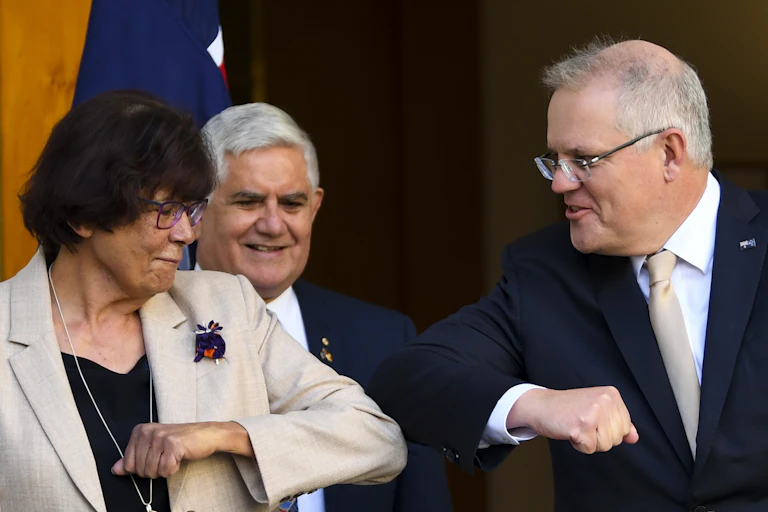 Indigenous leader Pat Turner elbow bumping Prime Minister Scott Morrison, as Minister for Indigenous Affairs Ken Wyatt looks on, smiling