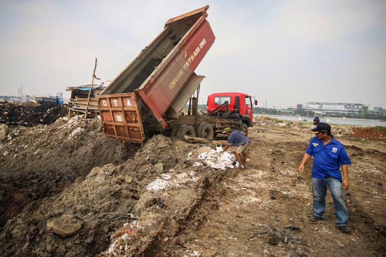 Truk menuangkan pasir.