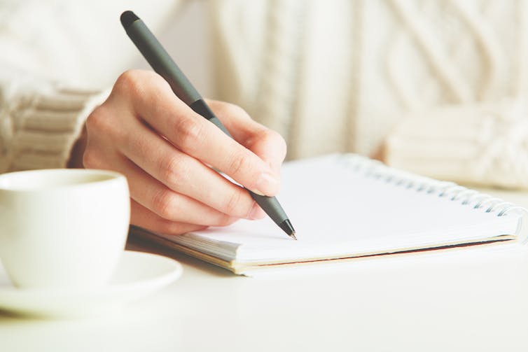 A woman writes in a notebook