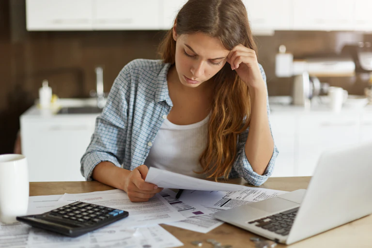 Worried woman looking at bills.