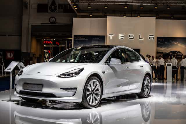 White Tesla Model 3 car on motor show stand