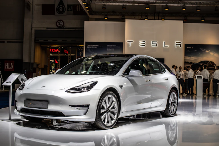 White Tesla Model 3 car on motor show stand