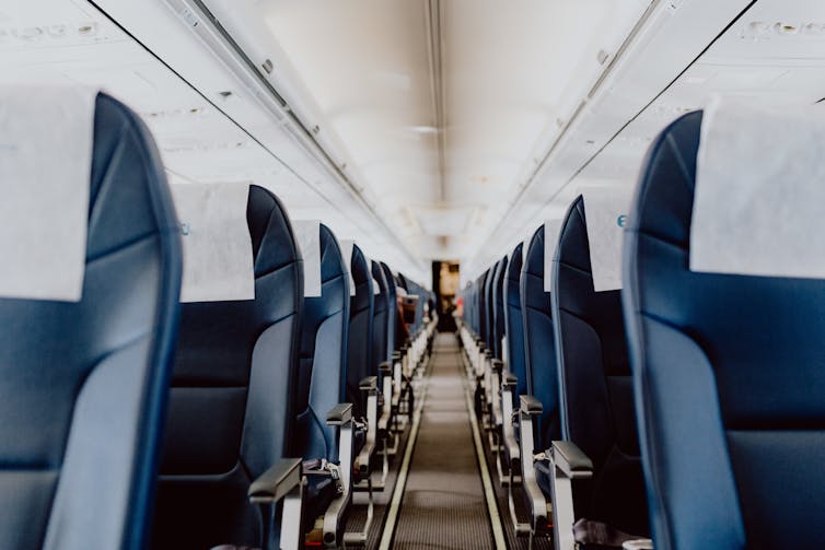 The empty interior of an airplane, with no passengers in any of the seats