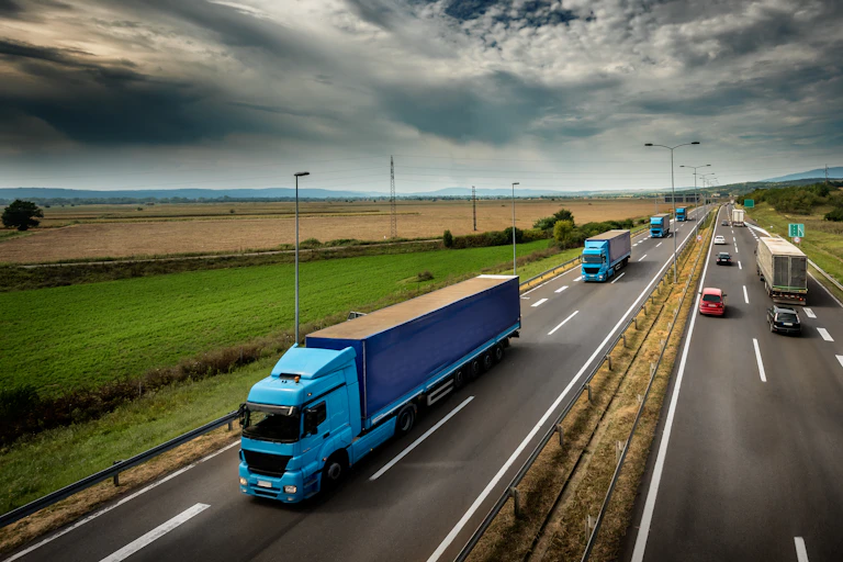 Transport trucks and cars on a four-lane highway