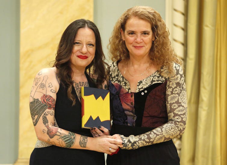 Governor General Julie Payette and author Cherie Dimaline pose for a photo at the Governor General's Literary Award for English young people's literature. Dimaline is holding a book in her left hand.