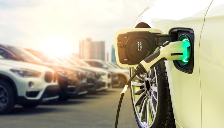 An electric car being charged in a parking lot.