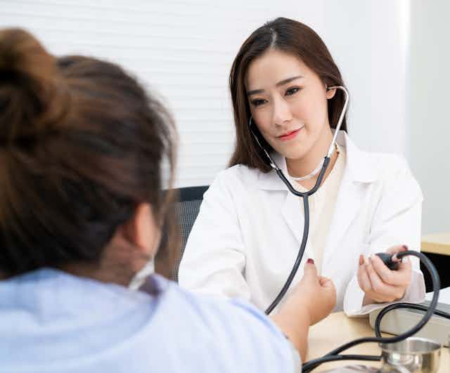 A doctor is taking her patient's blood pressure