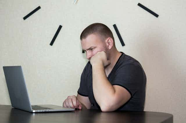 Student staring at laptop screen as they try to write an assignment