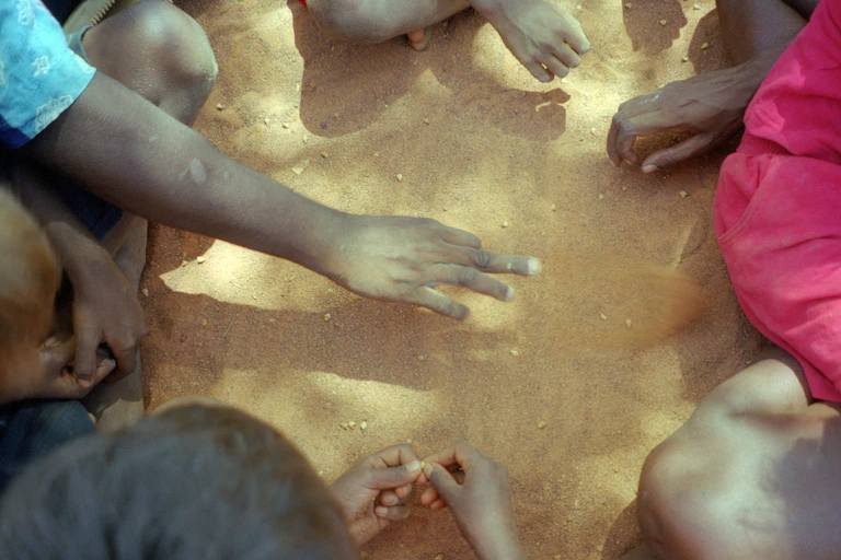 Hands of Indigenous Australians sitting in circle