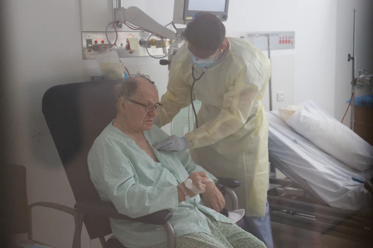 Elderly man being tended to by a hospital doctor