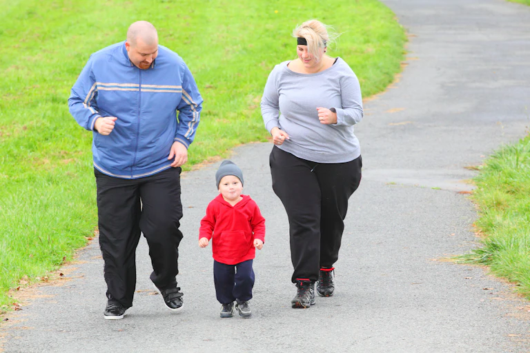 Overweight parents jog with their toddler.