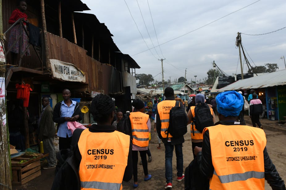 Census workers walk past vendors in a Nairobi street