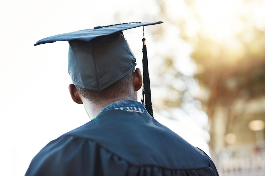 Young man in graduation gown and cap
