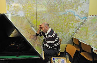 Hombre estudiando enormes mapas de Londres