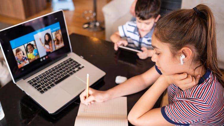 Teenage girl studying with video online lesson at home with her family amid widespread distance learning.