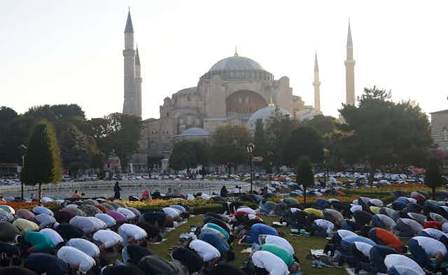 Muslims are seen praying outside Hagia Sophia.