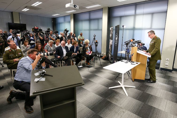 Military officer speaking to journalists at a press conference