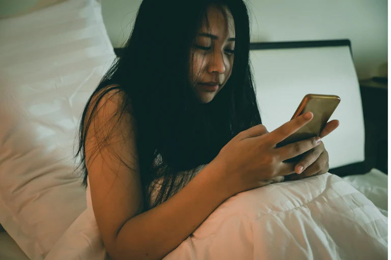 Woman on phone in bed