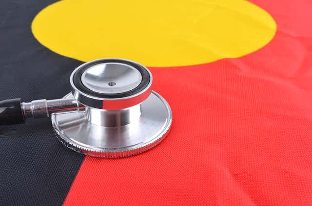 A stethoscope rests on the Aboriginal flag.